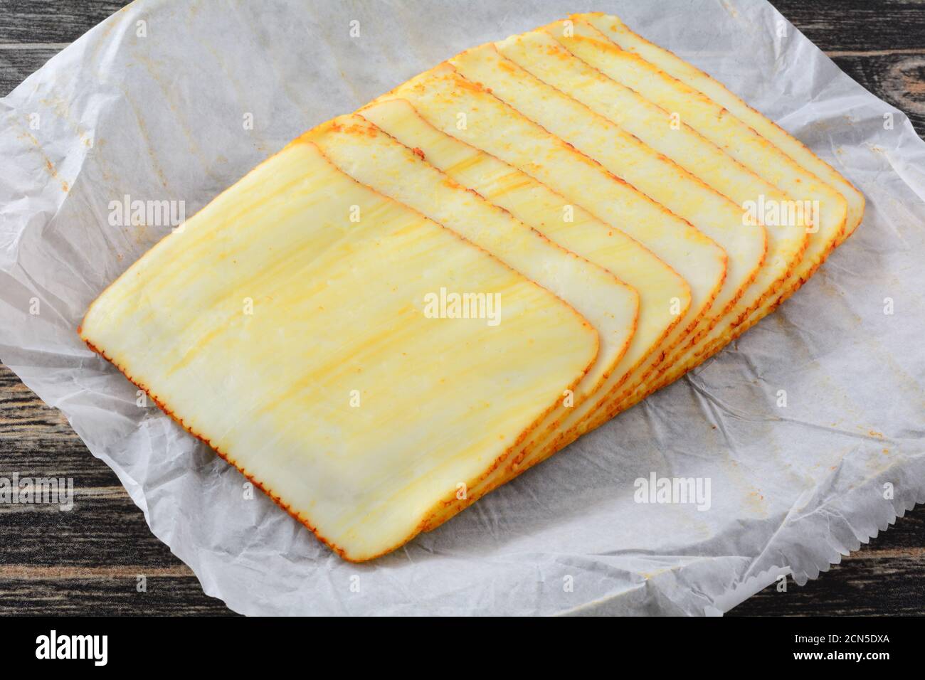 Stack of muenster cheese slices on white paper butcher paper Stock Photo