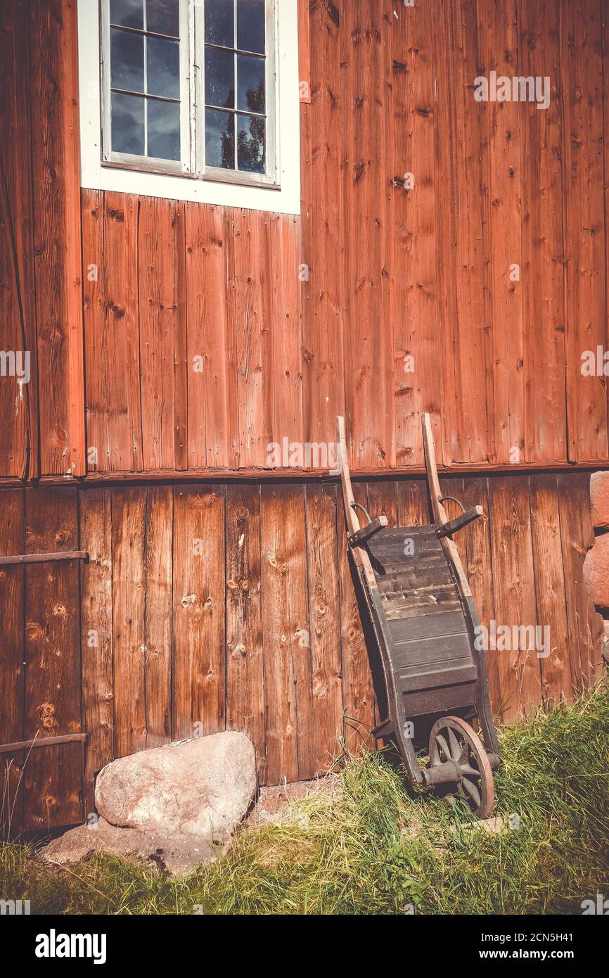 Old wooden wheelbarrow on a farm wall Stock Photo
