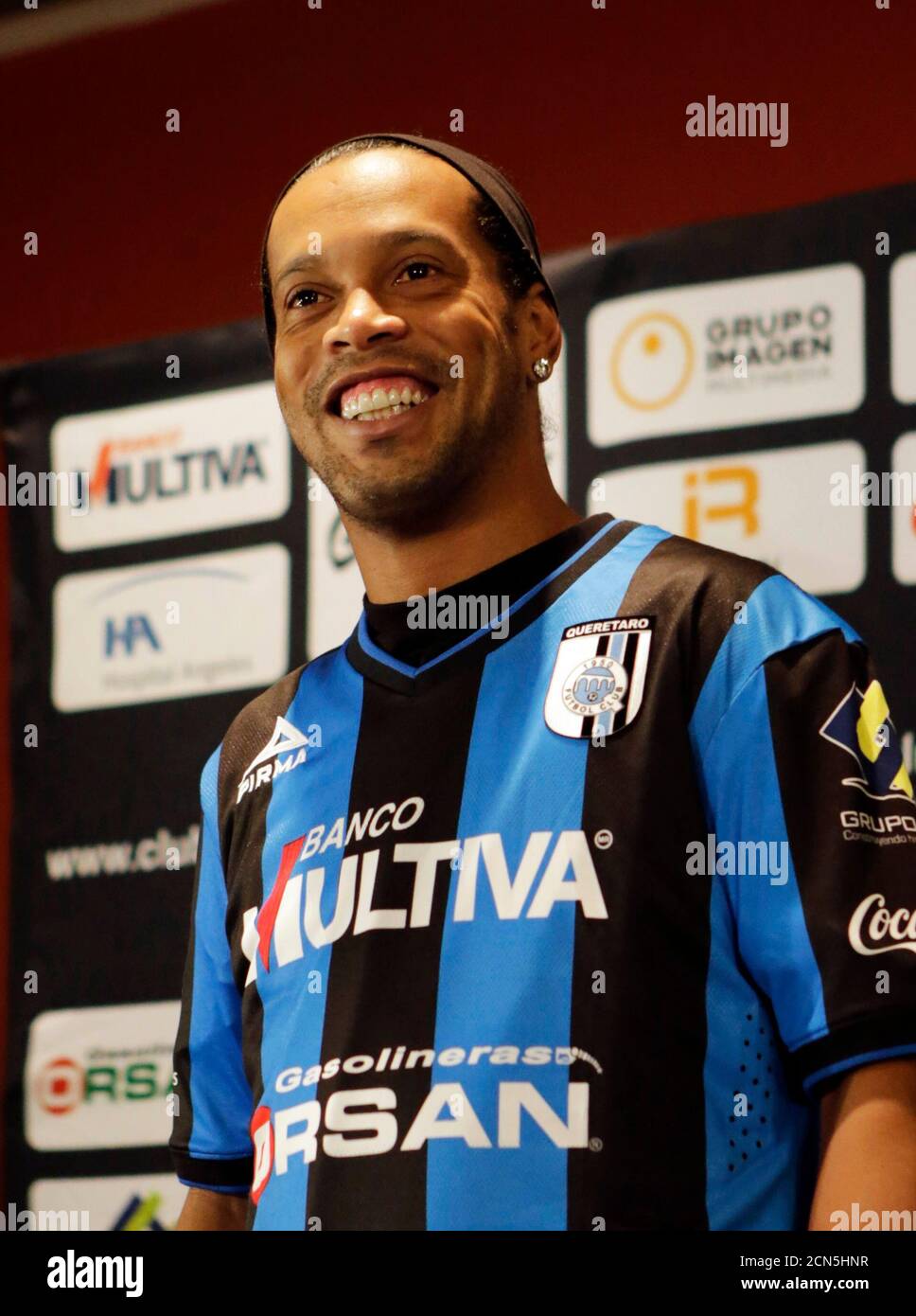 Soccer player Ronaldinho smiles while wearing his new club jersey during a  news conference in Mexico City September 12, 2014. Former Brazil and  Barcelona midfielder Ronaldinho, twice the World Player of the