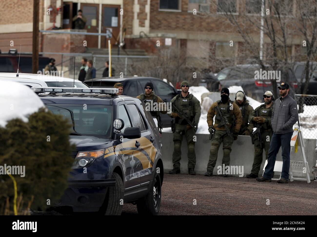 Law enforcement officers watch as pro-militia supports and anti-militia demonstrators protest outside the Harney County Courthouse in Burns, Oregon February 1, 2016. The deeply divided town of Burns, Oregon, braced Monday for possible tension between demonstrators on both sides of an armed occupation of a federal wildlife refuge, days after one of the occupiers was shot dead by state police. REUTERS/Jim Urquhart Stock Photo