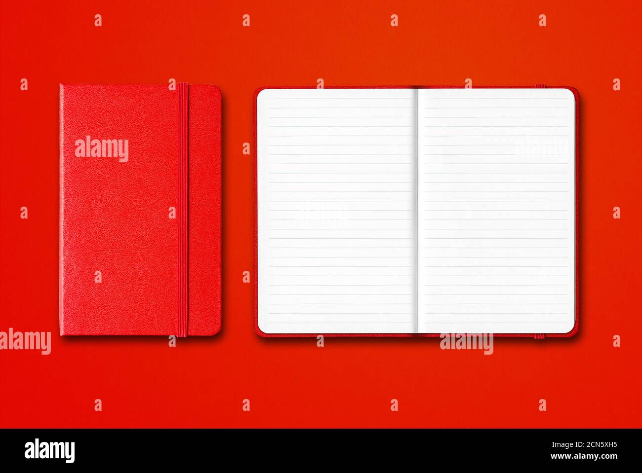 Red closed and open lined notebooks isolated on colorful background Stock Photo