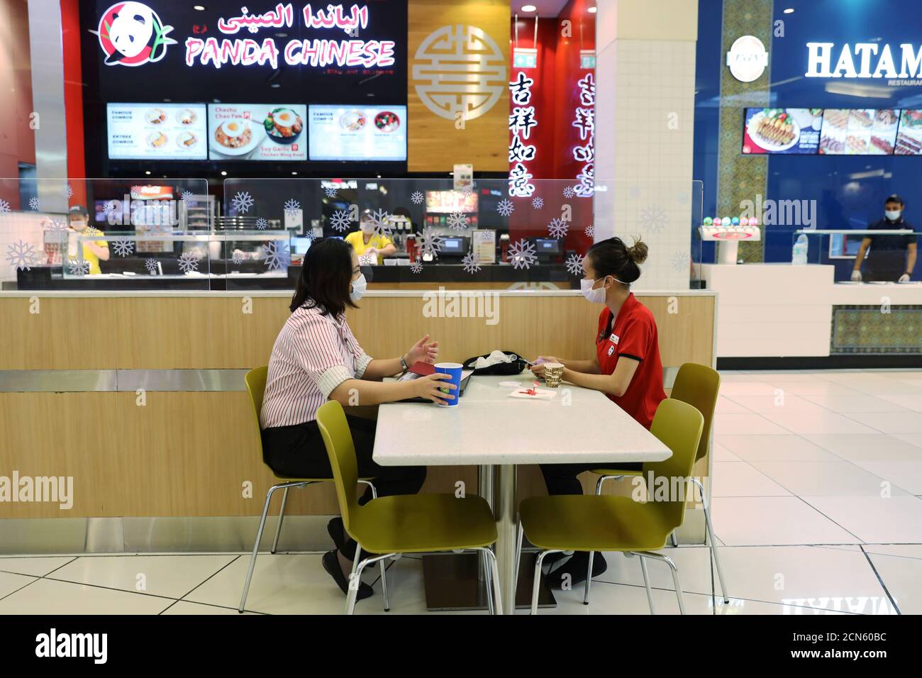People wearing protective face masks are seen in the food court at Mall of  the Emirates after the UAE government eased a curfew and allowed stores to  reopen, following the outbreak of