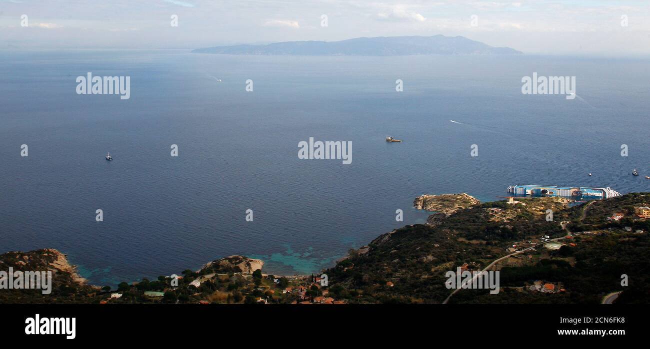 A view of the Costa Concordia cruise ship (bottom R) that ran aground off the west coast of Italy, at Giglio island, January 18, 2012. Divers searching the capsized Italian cruise liner Costa Concordia suspended work on Wednesday after the vast wreck shifted slightly but officials said they are hoping to resume as soon as possible. REUTERS/ Max Rossi (ITALY - Tags: DISASTER TRANSPORT) Stock Photo
