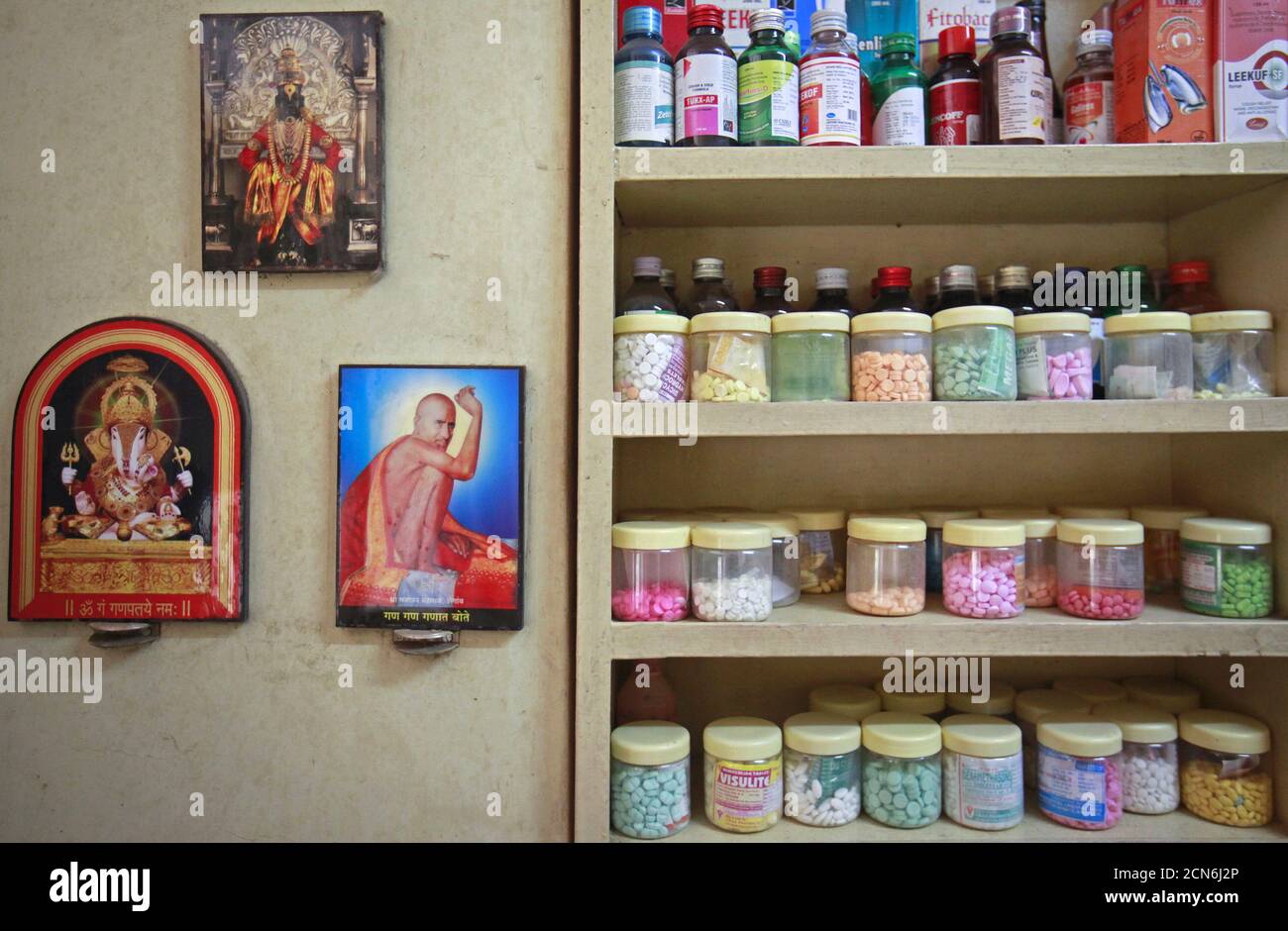 Pictures of Hindu gods hang beside a medicine rack inside a clinic in Pune, India, in this August 27, 2012 file photo. To match INDIA-MEDICINE/PATENTS  REUTERS/Danish Siddiqui/Files Stock Photo