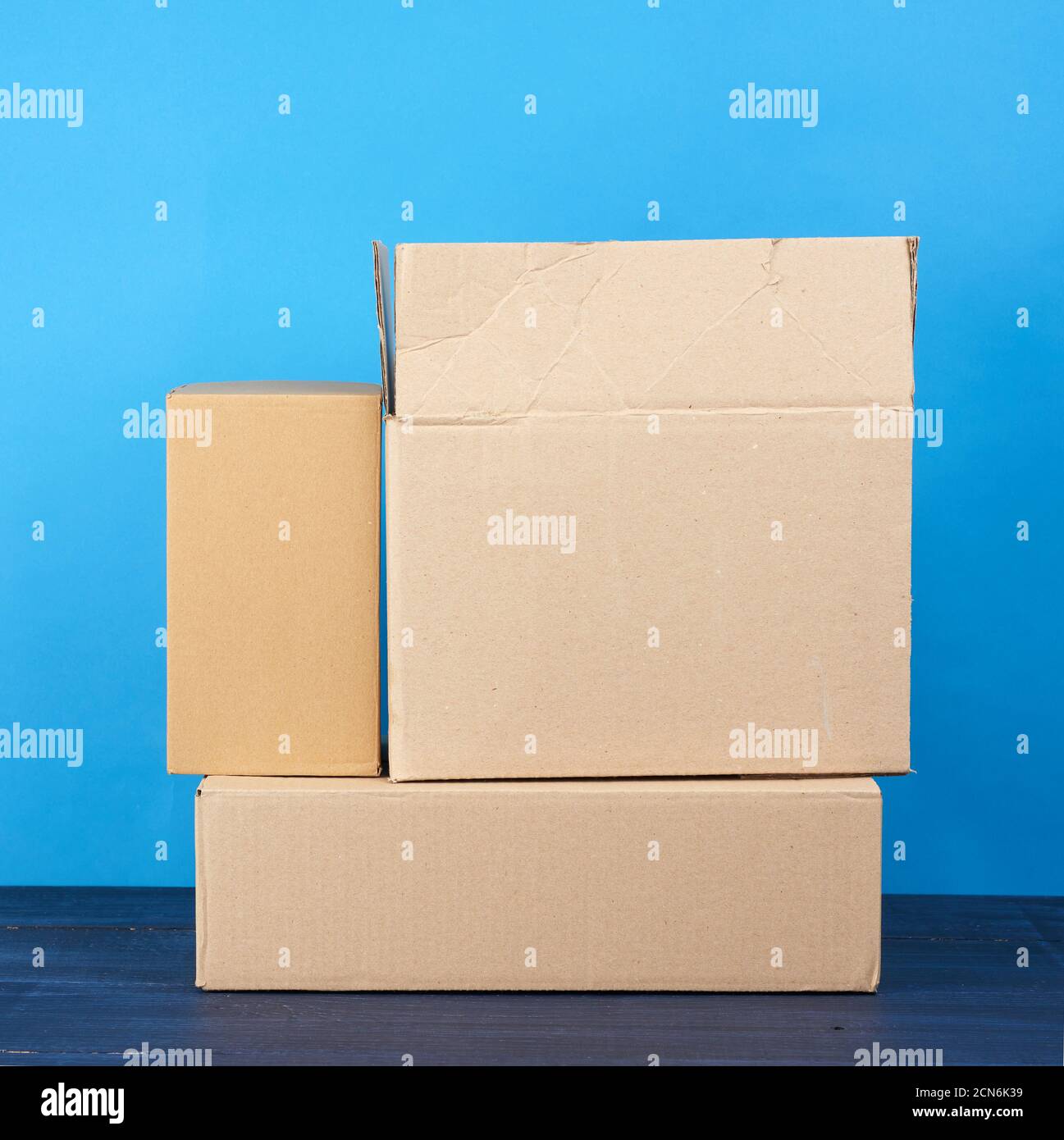 stack of cardboard boxes of brown kraft paper on a blue wooden table Stock Photo