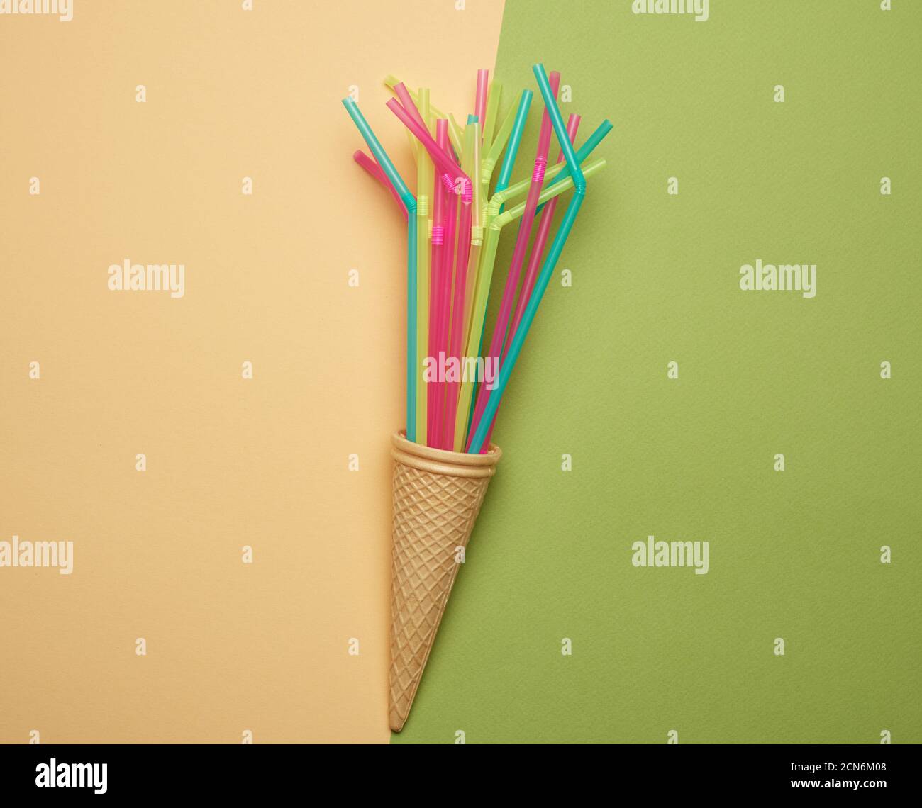 stack of plastic multi-colored cocktail tubes on a green background Stock Photo
