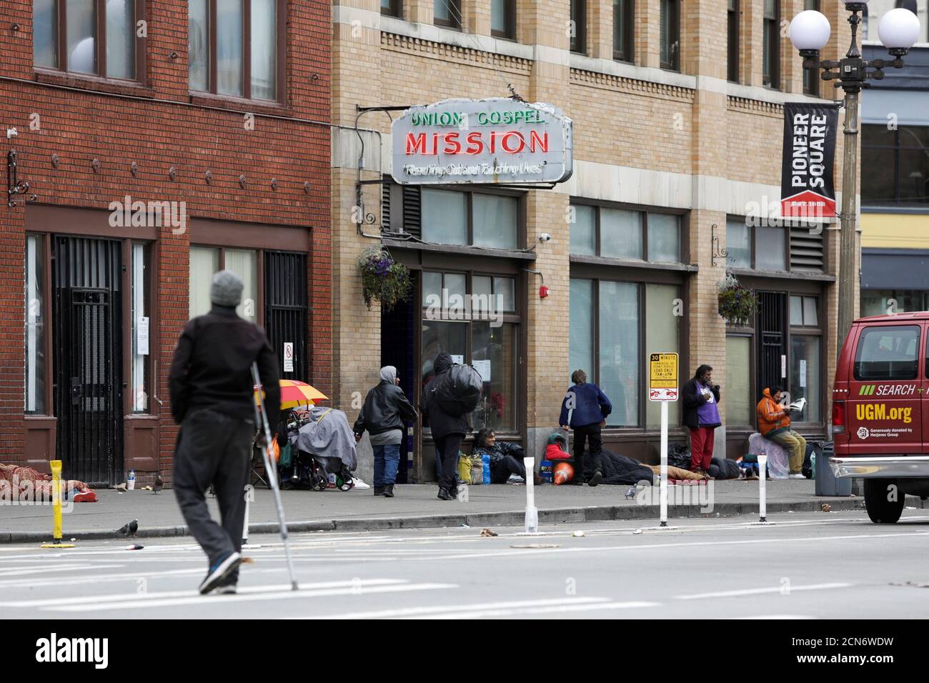 People are pictured outside the Union Gospel Mission Men's Shelter in Pioneer Square, after a confirmed case of COVID-19 at their Riverton Place location led to a 14-day lockdown at all Mission Program sites, according to their website, as efforts continue to help slow the spread of coronavirus disease (COVID-19) in Seattle, Washington, U.S. March 28, 2020.  REUTERS/Jason Redmond Stock Photo