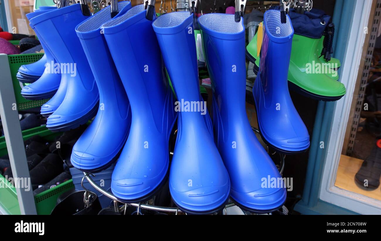 blue rubber boots in front of the shoe store Stock Photo