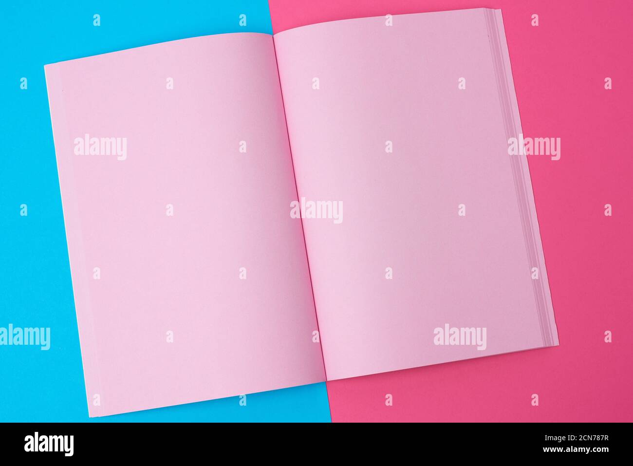 open notebook with blank pink pages on a blue background Stock Photo