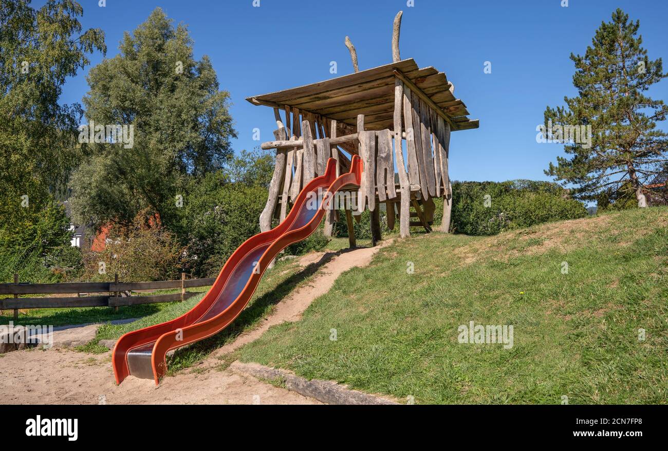 Wooden playhouse with wave slide at a playground Stock Photo Alamy