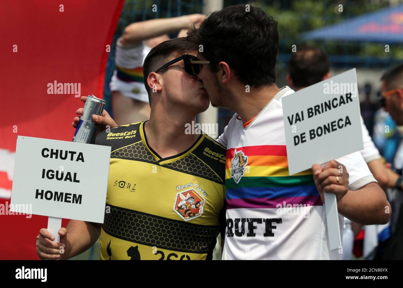Soccer players of the Unicorns (R) and Bee Cats soccer teams hold placards during the opening ceremony of the Champions LiGay, a gay soccer tournament in Sao Paulo, Brazil November 2, 2018. Picture taken November 2, 2018. Placards read: 'Kick as a male' and 'Go play with doll'. REUTERS/Paulo Whitaker Stock Photo