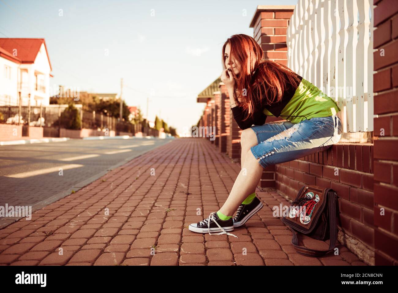 Lovely young redhead woman with earphones at uptown street sunset Stock Photo