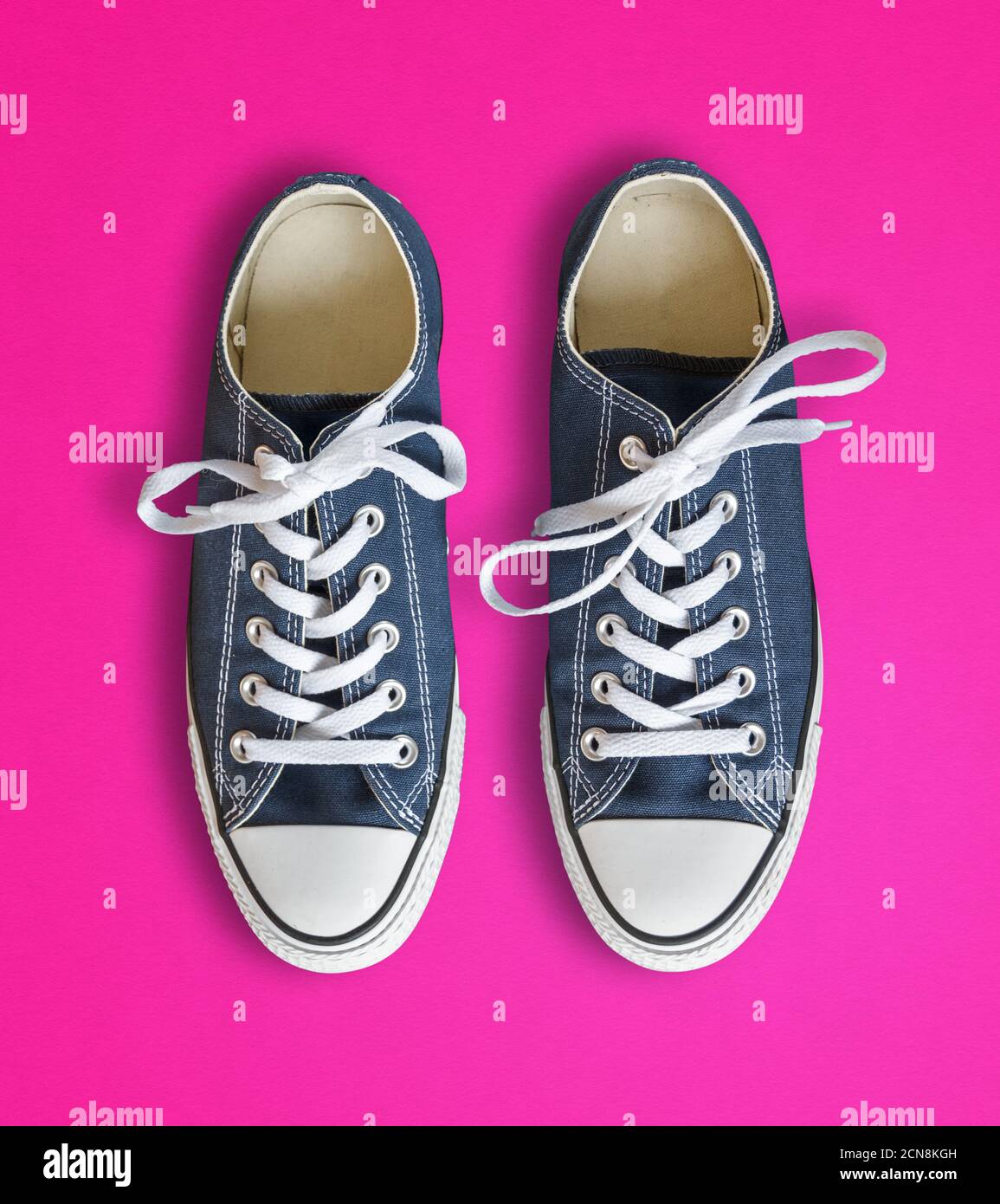 Blue sneakers isolated on pink background Stock Photo - Alamy