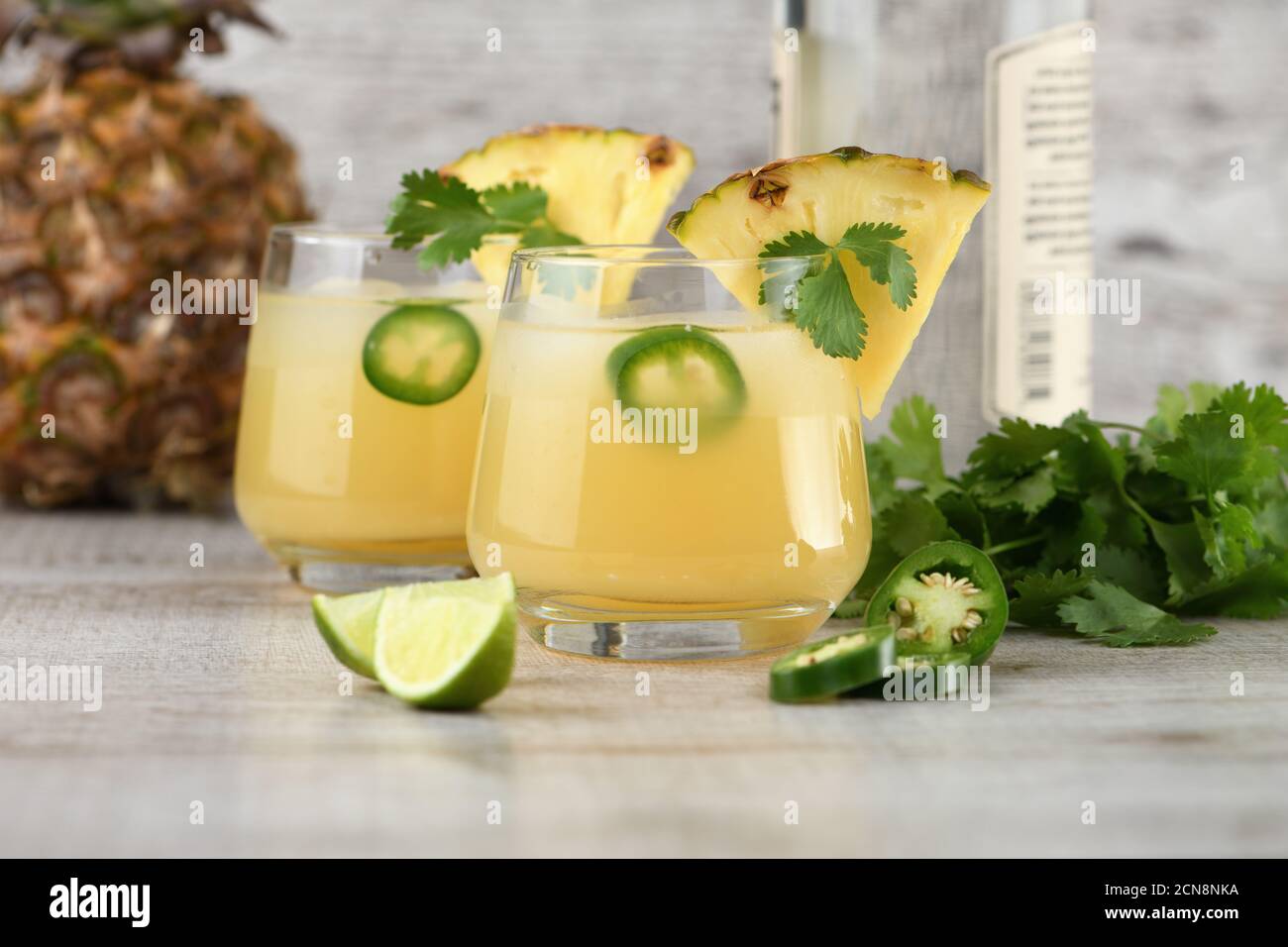 Tequila cocktail with pineapple juice, jalapeno slices and cilantro