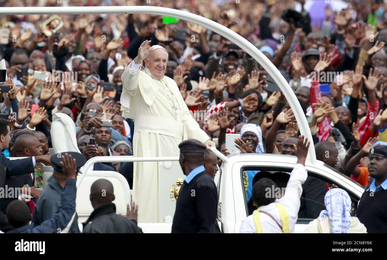 Pope Francis waves to faithful while riding in an open truck as he arrives for a Papal mass in Kenya's capital Nairobi, November 26, 2015. In actions and words on his first tour of the world's poorest continent, Pope Francis has sent a message to African leaders that they could do with less pomp and a bit more humility. Francis, who has spurned many of the institutional perks of the Vatican, shunned the armoured cars with tinted glass driven by President Uhuru Kenyatta and his entourage. REUTERS/Thomas Mukoya Stock Photo