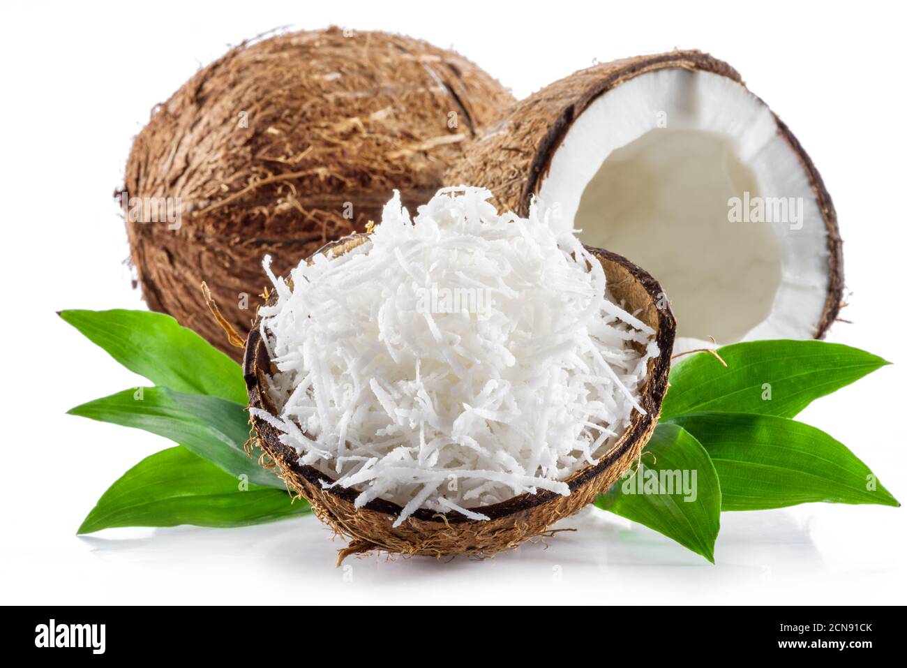 Coconut fruit and shredded coconut flakes in the piece of shell isolated on white background. Stock Photo
