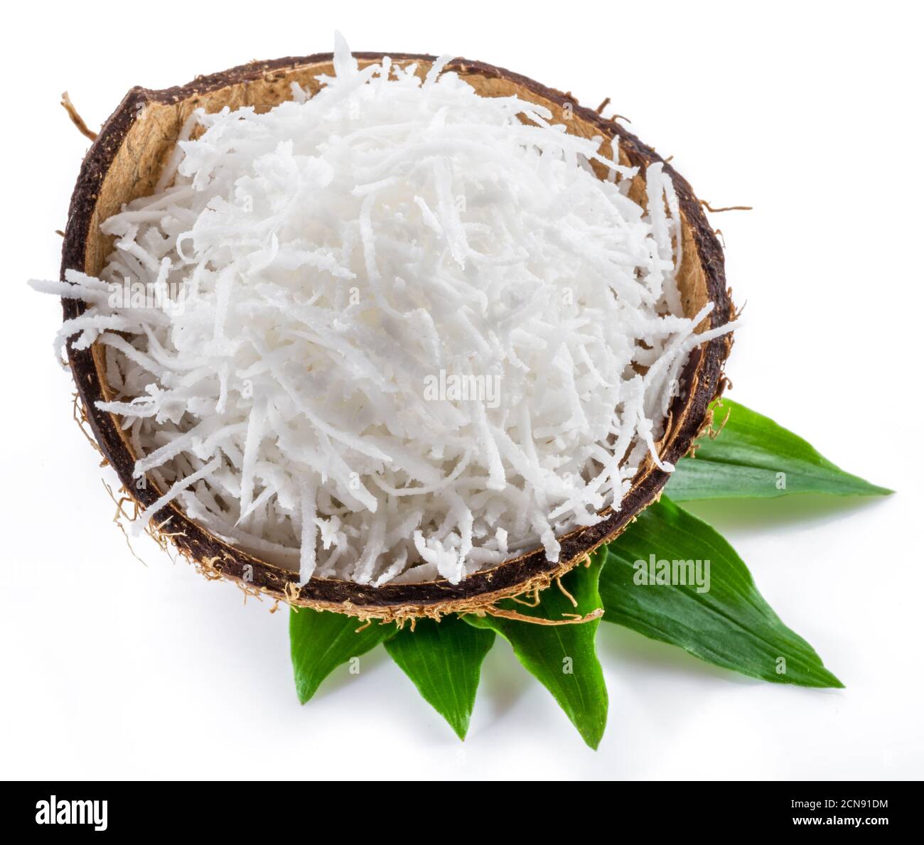 Shredded coconut flakes in the coconut shell isolated on white