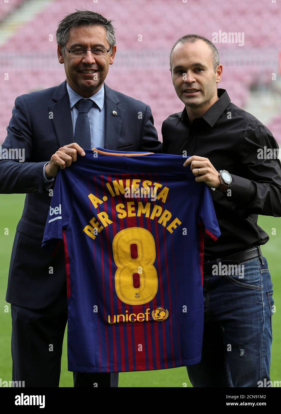 FC Barcelona captain Andres Iniesta holds up a jersey with FC Barcelona's  President Josep Maria Bartomeu after announcing the agreement of a contract  for life with FC Barcelona, in Barcelona, Spain, October