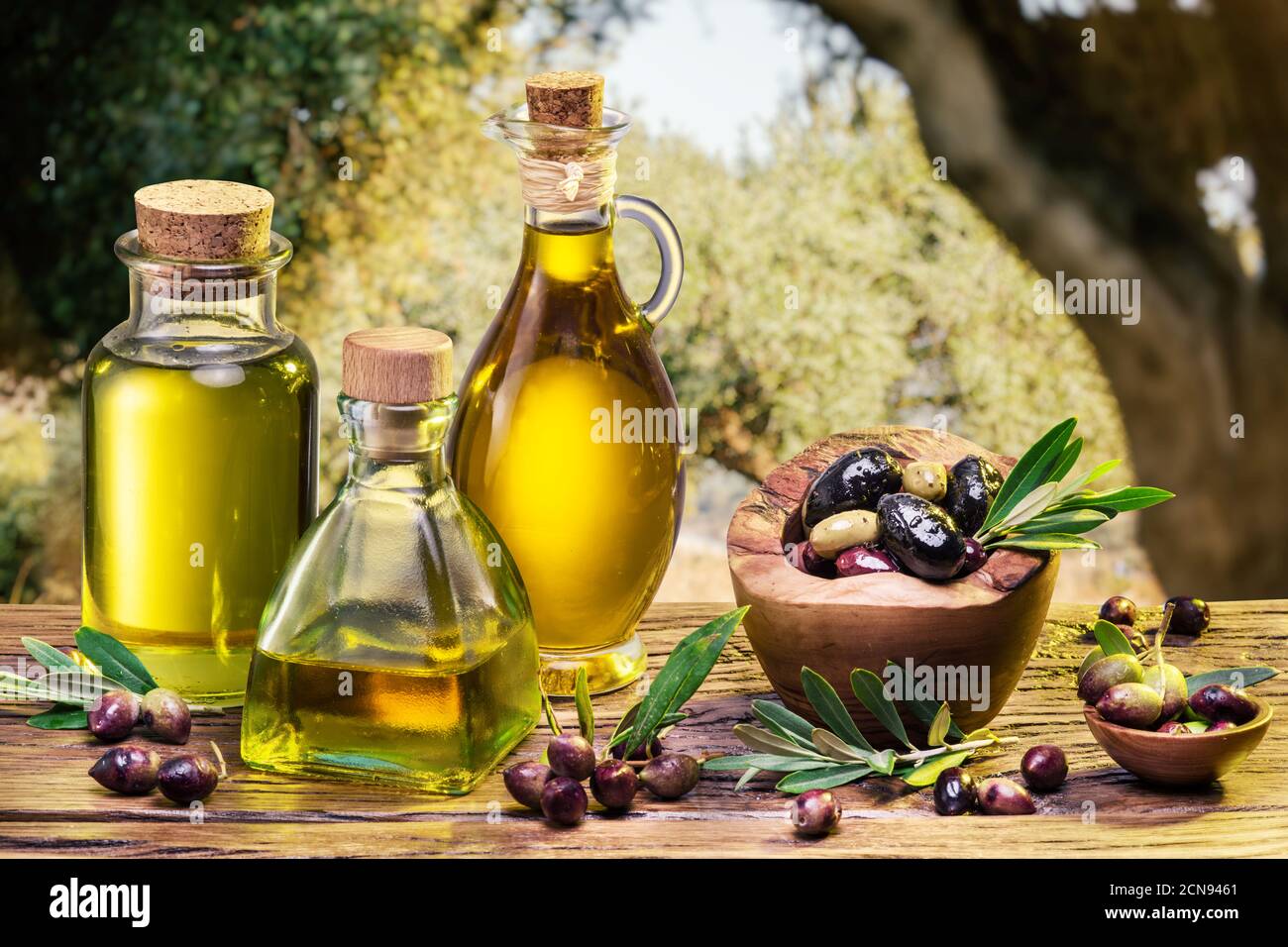 Ripe natural olives with bottles of olive oil on a vintage old wooden ...