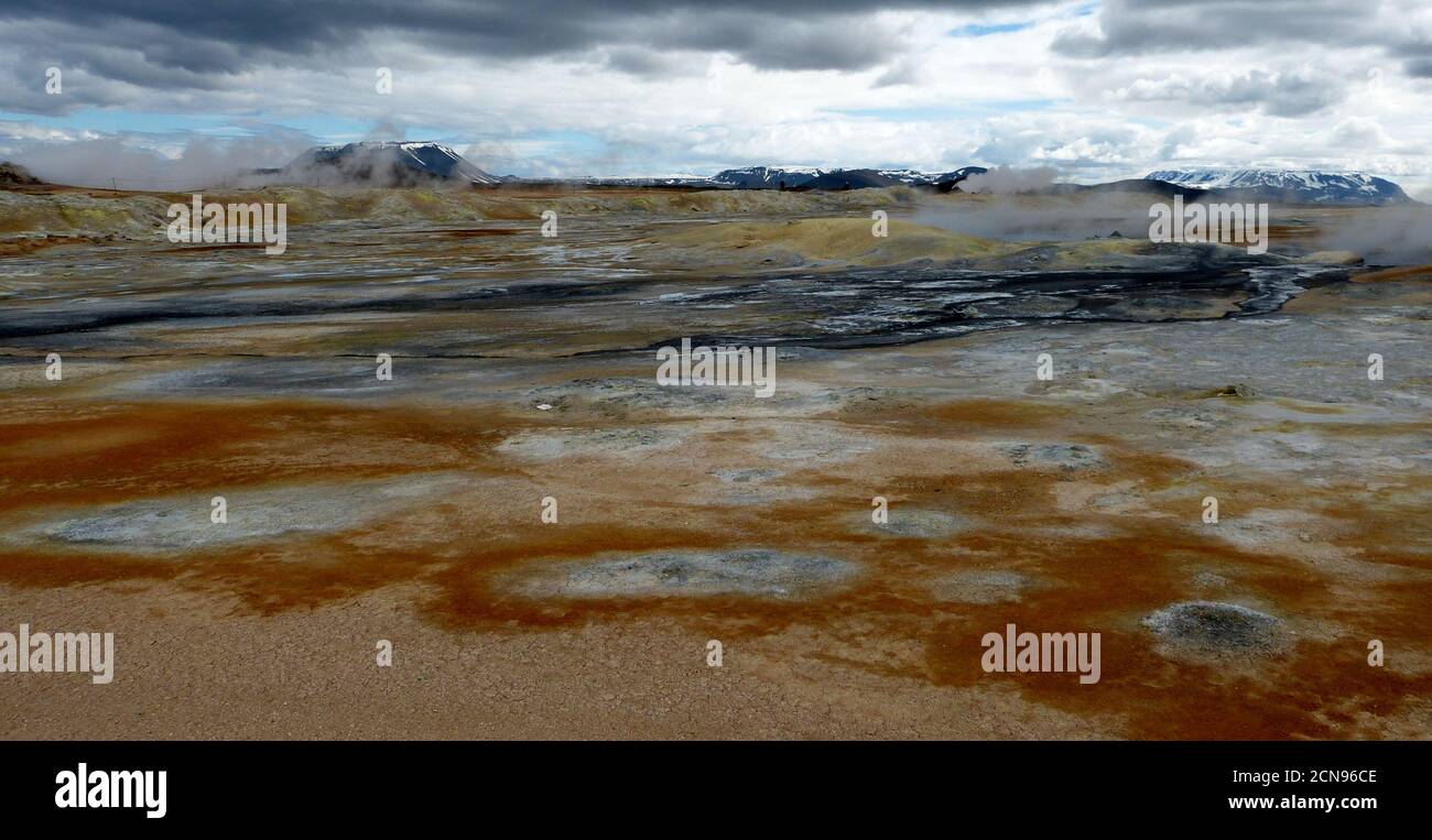 Surreal geothermal valley Hverir in Iceland, volcano Crafla, geysers fumarole, cracked earth like alien Mars planet. Magical icelandic nature. Stock Photo