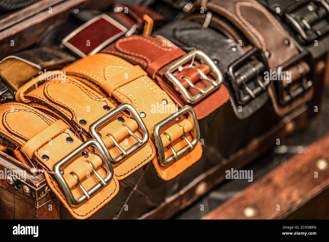 Leather belts with shiny gold-plated buckles. Handmade from genuine cowhide leather Stock Photo