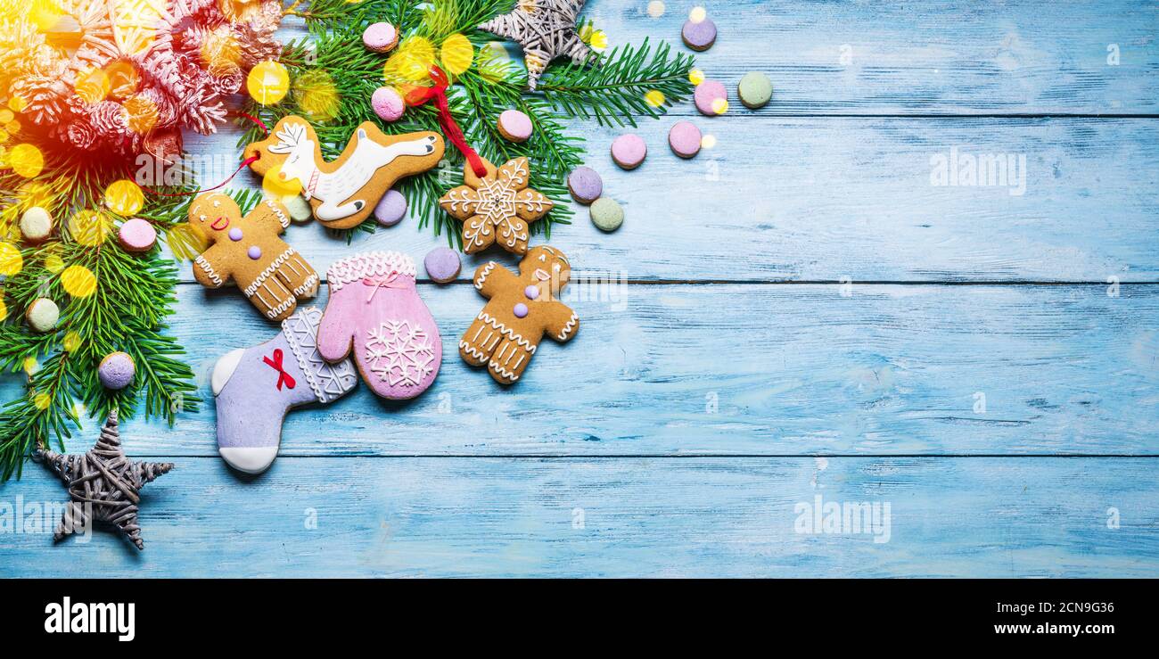 Blue wooden background with christmas decor and traditional ginger cookies. Christmas or New Year holiday background. Top view. Stock Photo