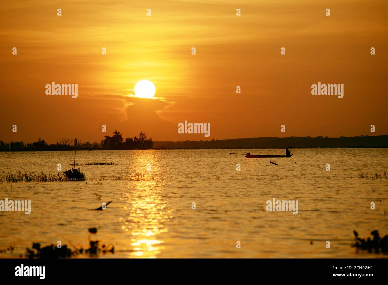 Asian fisherman catches fish by fishing on a boat in a swamp in Thailand. Stock Photo