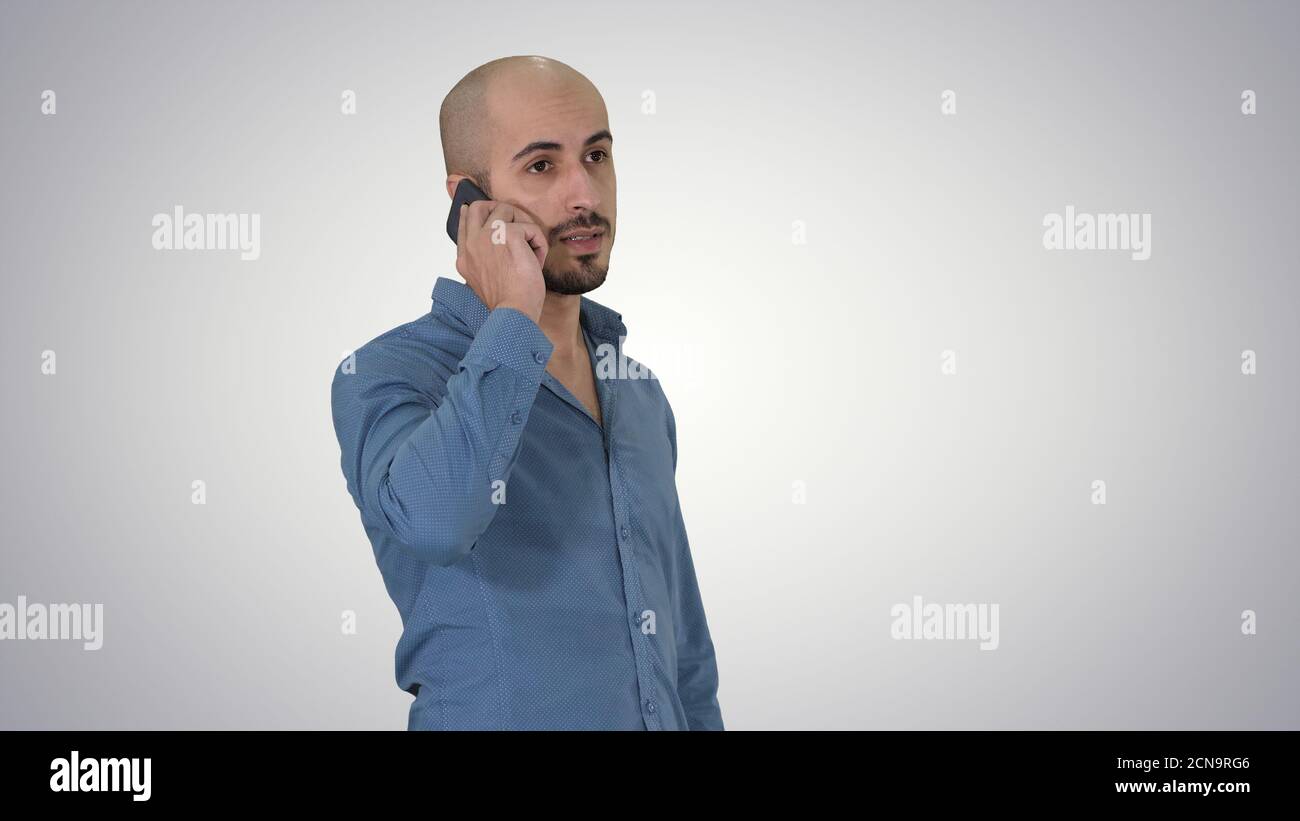 Serious arab talking on the phone on gradient background. Stock Photo