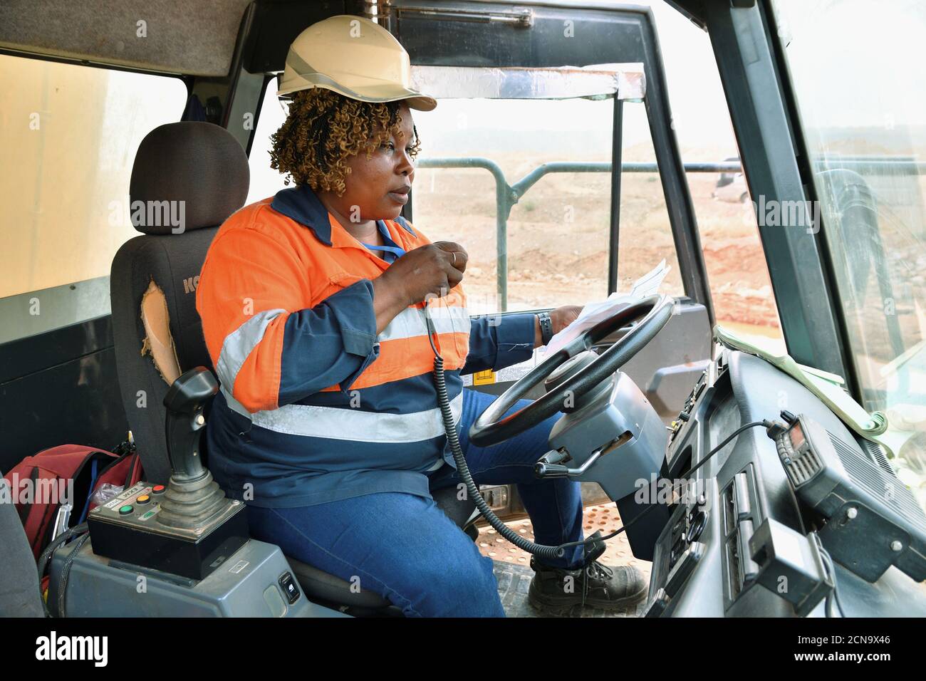 Tene Konate, 42, a truck driver, talks on a radio as she sits in her truck  at the gold mine site, operated by Endeavour Mining Corporation in Hounde,  Burkina Faso February 10,