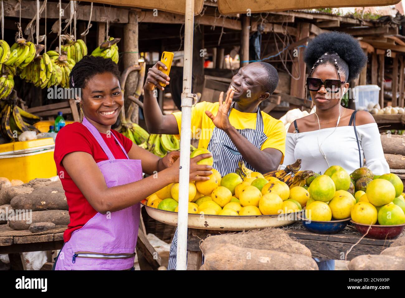 local african market scene with happy traders selling, one using his ...