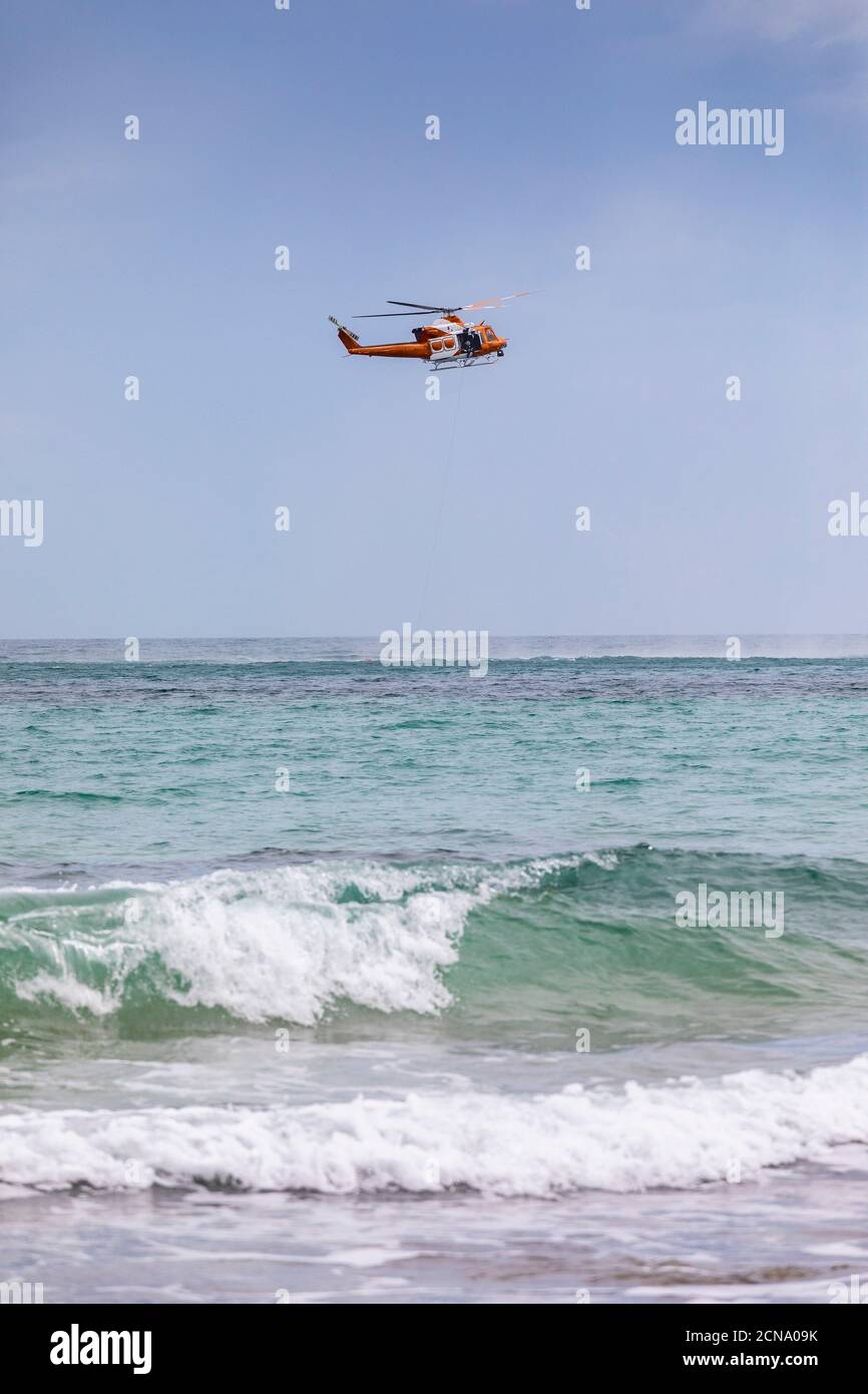 Rescue helicopter training over sunny ocean, Adelaide, Australia Stock Photo