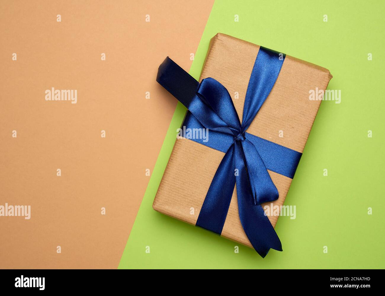 rectangular box wrapped in brown paper and tied with a silk ribbon with ...