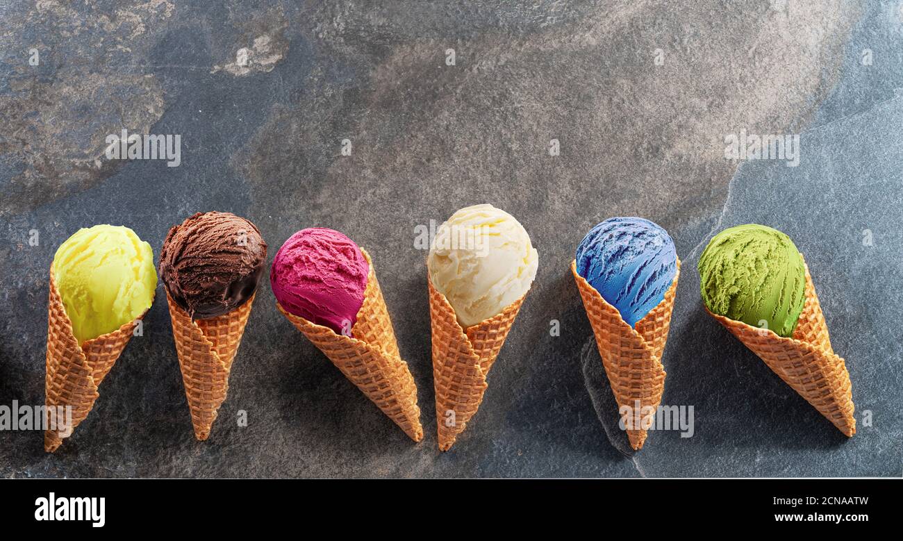 https://c8.alamy.com/comp/2CNAATW/set-of-various-colorful-ice-creams-in-waffle-cones-on-the-grey-background-lay-out-view-2CNAATW.jpg