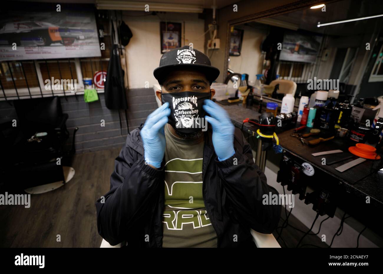 Adiel Sadie adjusts his face mask in his empty barbers shop, closed under the coronavirus disease (COVID-19) lockdown regulations in Bonteheuwel township in Cape Town, South Africa, June 7, 2020. Picture taken  June 7, 2020. REUTERS/Mike Hutchings Stock Photo