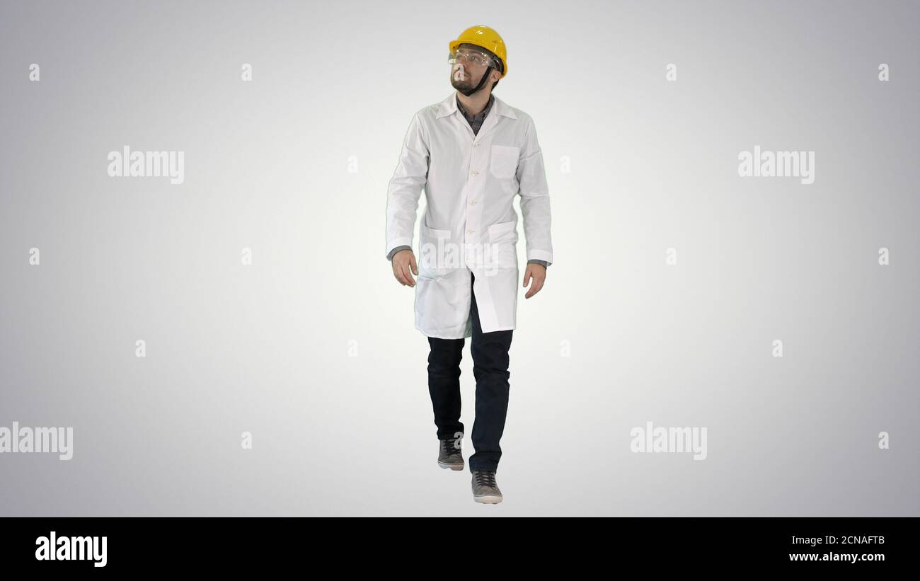 Engineer putting on protactive glasses while walking on gradient Stock Photo