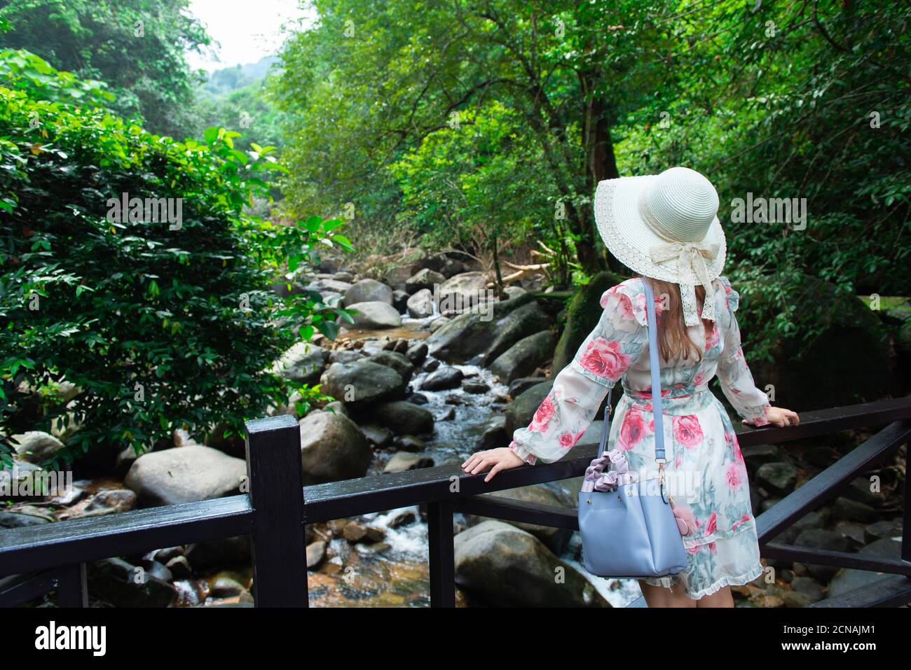 Asian girl tourists visit the beauty of nature in Phlio Waterfall National Park sign at Chanthaburi, Thailand. Stock Photo