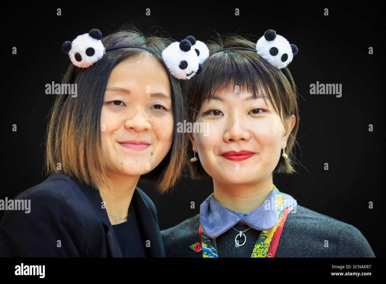 Two women with Panda accessories, representing China at World Travel Market, ExCel London, UK Stock Photo