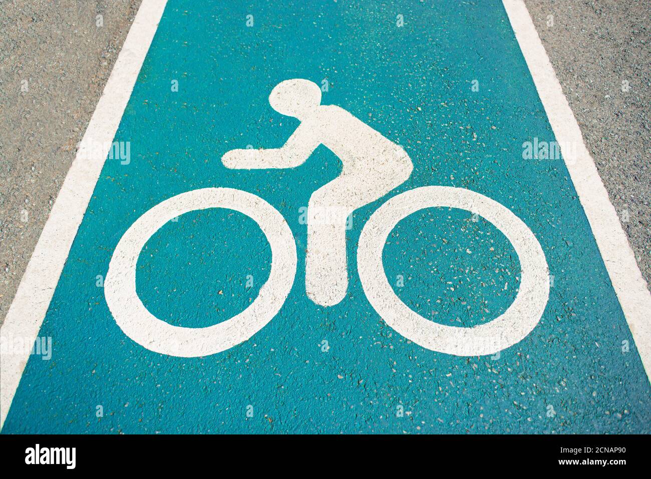 Separate bicycle lane for riding bicycles.Bicycle icon on the lane .New public asphalt bicycle lane  close up beside the road.White painted bike on as Stock Photo