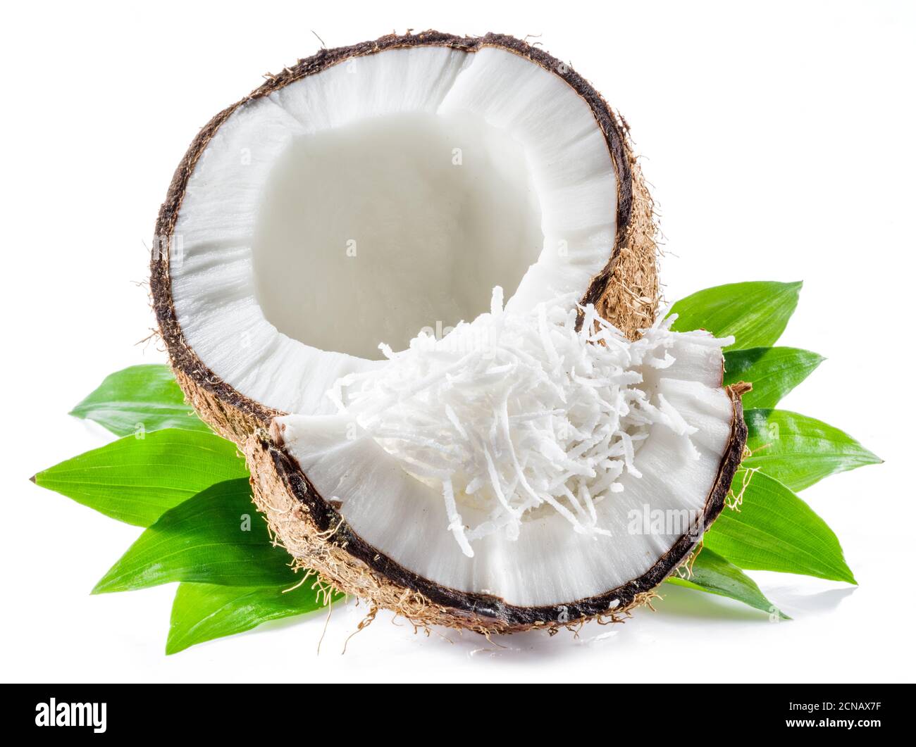 Cracked coconut fruit with white flesh and shredded coconut flakes isolated on white background. Stock Photo