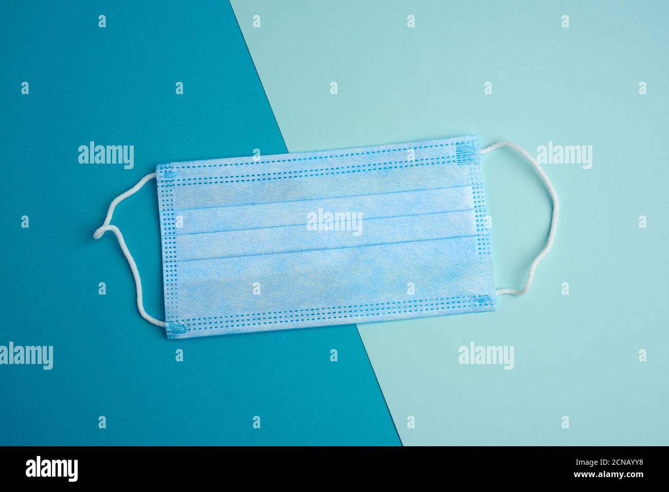 blue disposable medical mask on a blue background Stock Photo - Alamy