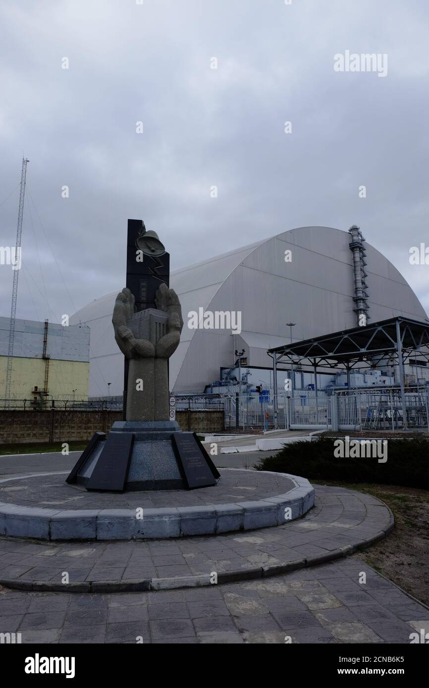 Pripyat, Ukraine, March 14, 2020. Monument to the liquidators of the accident at the Chernobyl nuclear power plant against the background of a protect Stock Photo