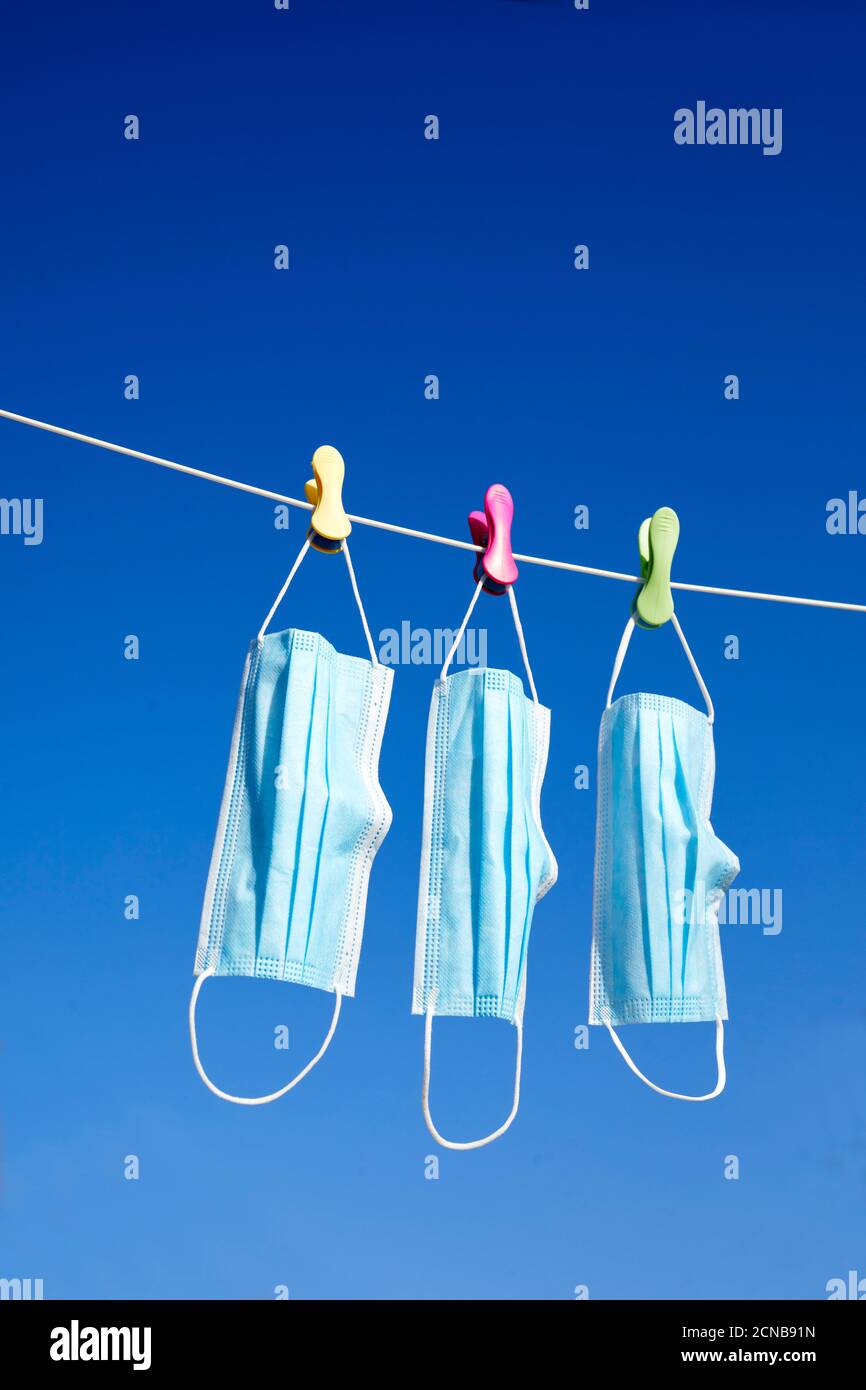 Surgical masks hanging on a washing line Stock Photo