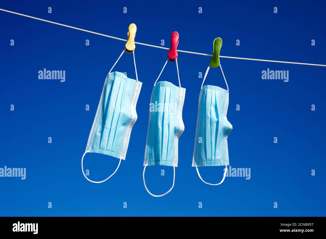 Surgical masks hanging on a washing line Stock Photo