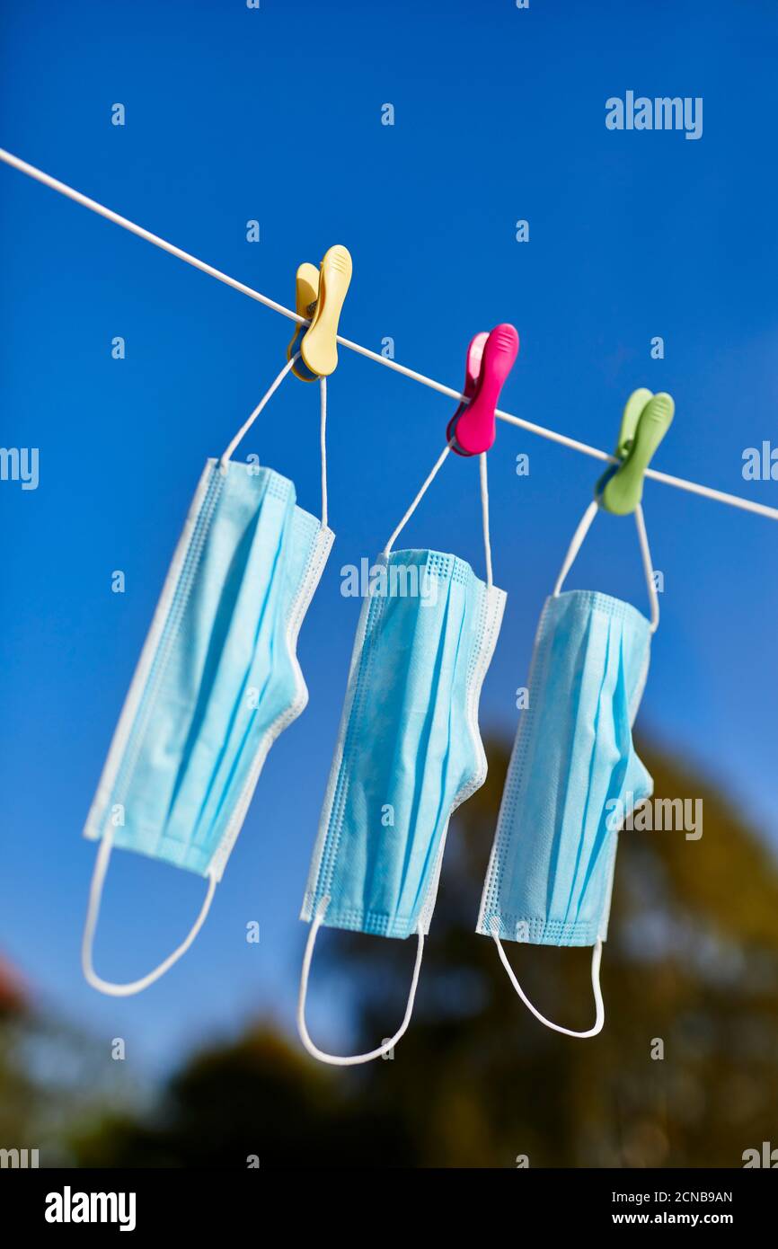 Surgical masks hanging on a washing line Stock Photo