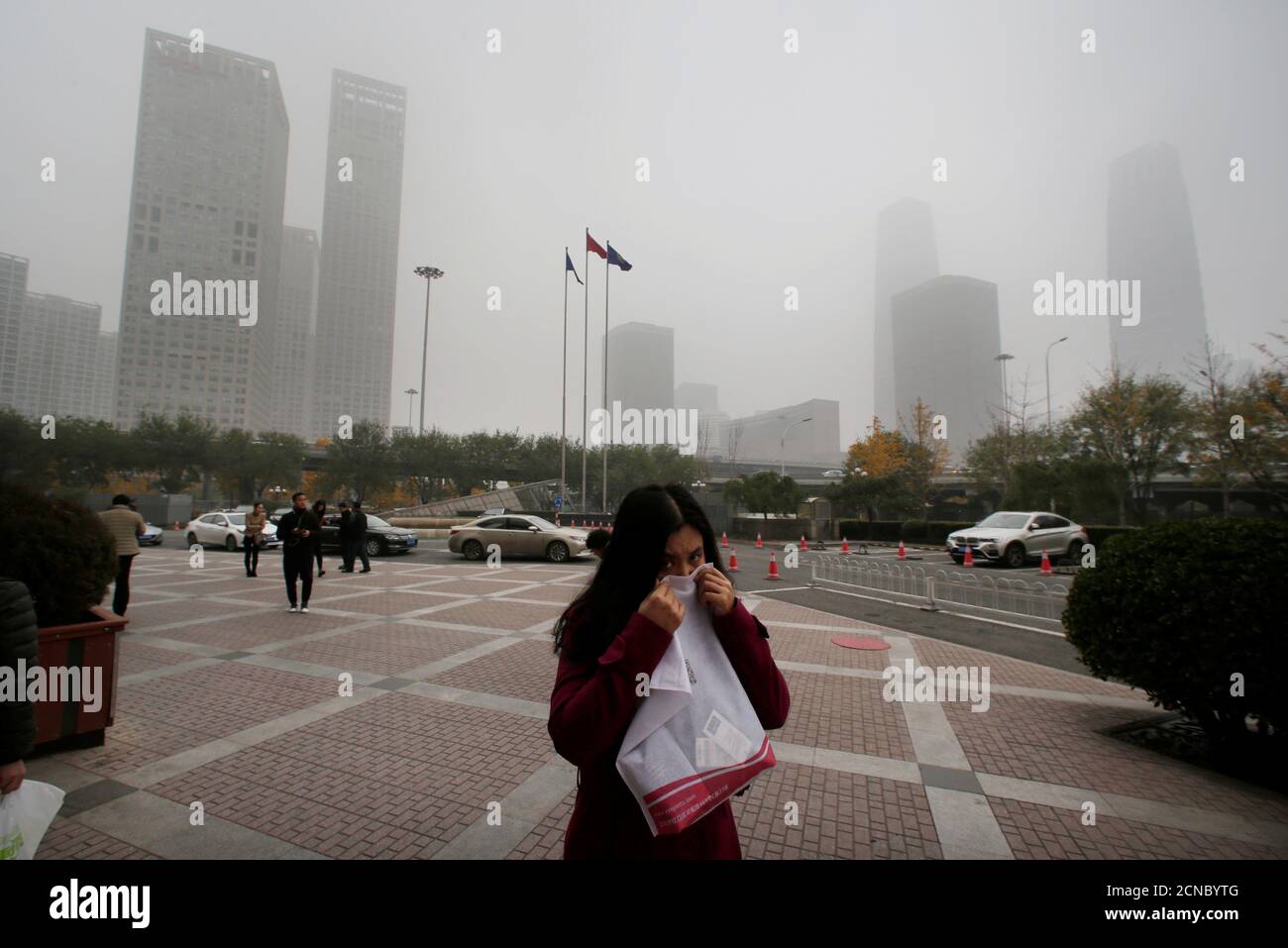 A woman covers her nose as she walks in the central business district ...