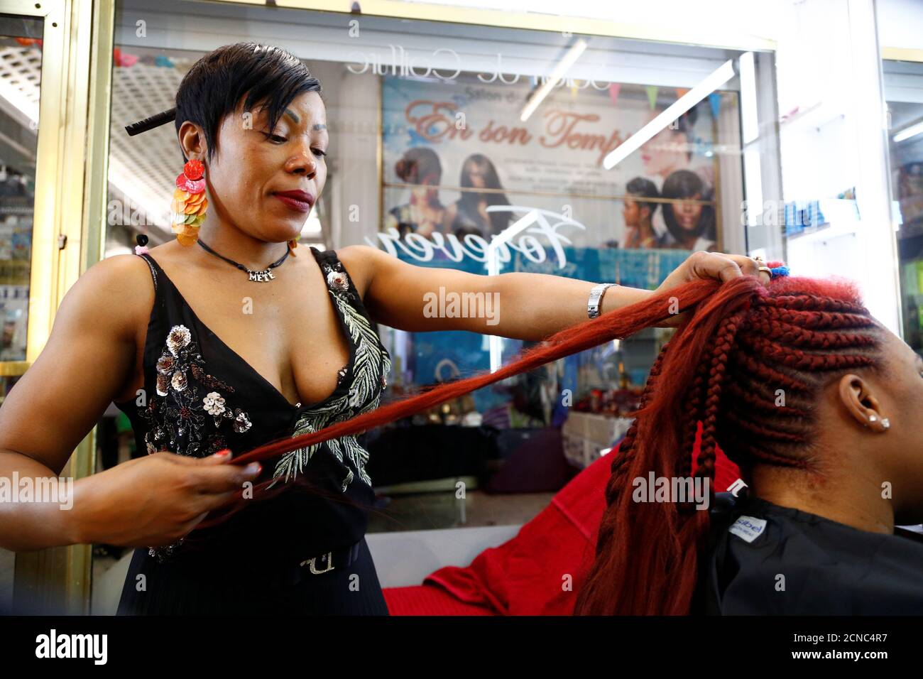 A hairdresser braids the hair of a client in a hair salon at the Matonge  gallery in Brussels, Belgium, June 13, 2020. Picture taken June 13, 2020.  REUTERS/Francois Lenoir Stock Photo - Alamy