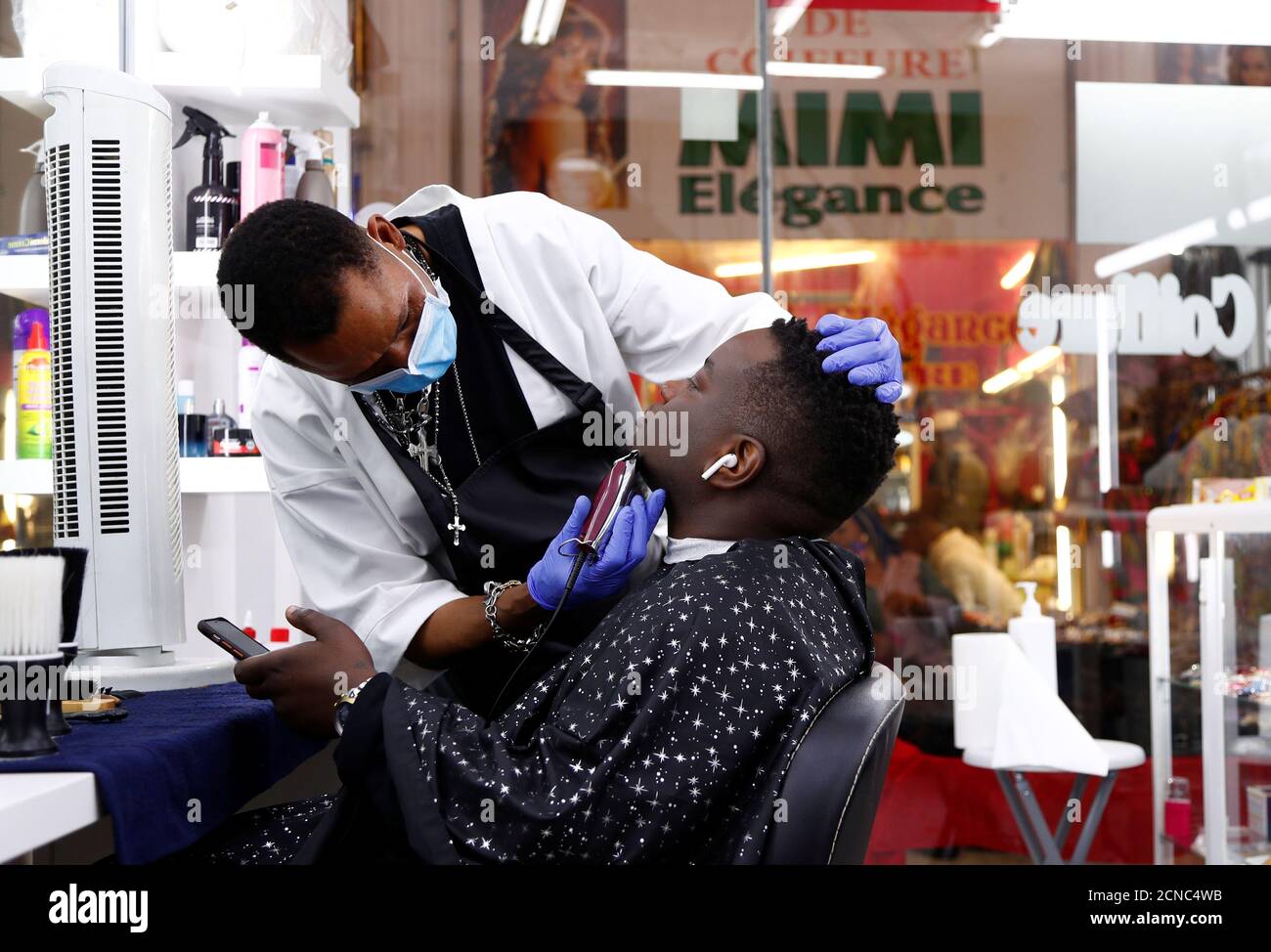 Hairdresser Ambrosio shaves a client in a hair salon of the Matonge gallery  in Brussels, Belgium, June 11, 2020. Picture taken June 11, 2020.  REUTERS/Francois Lenoir Stock Photo - Alamy