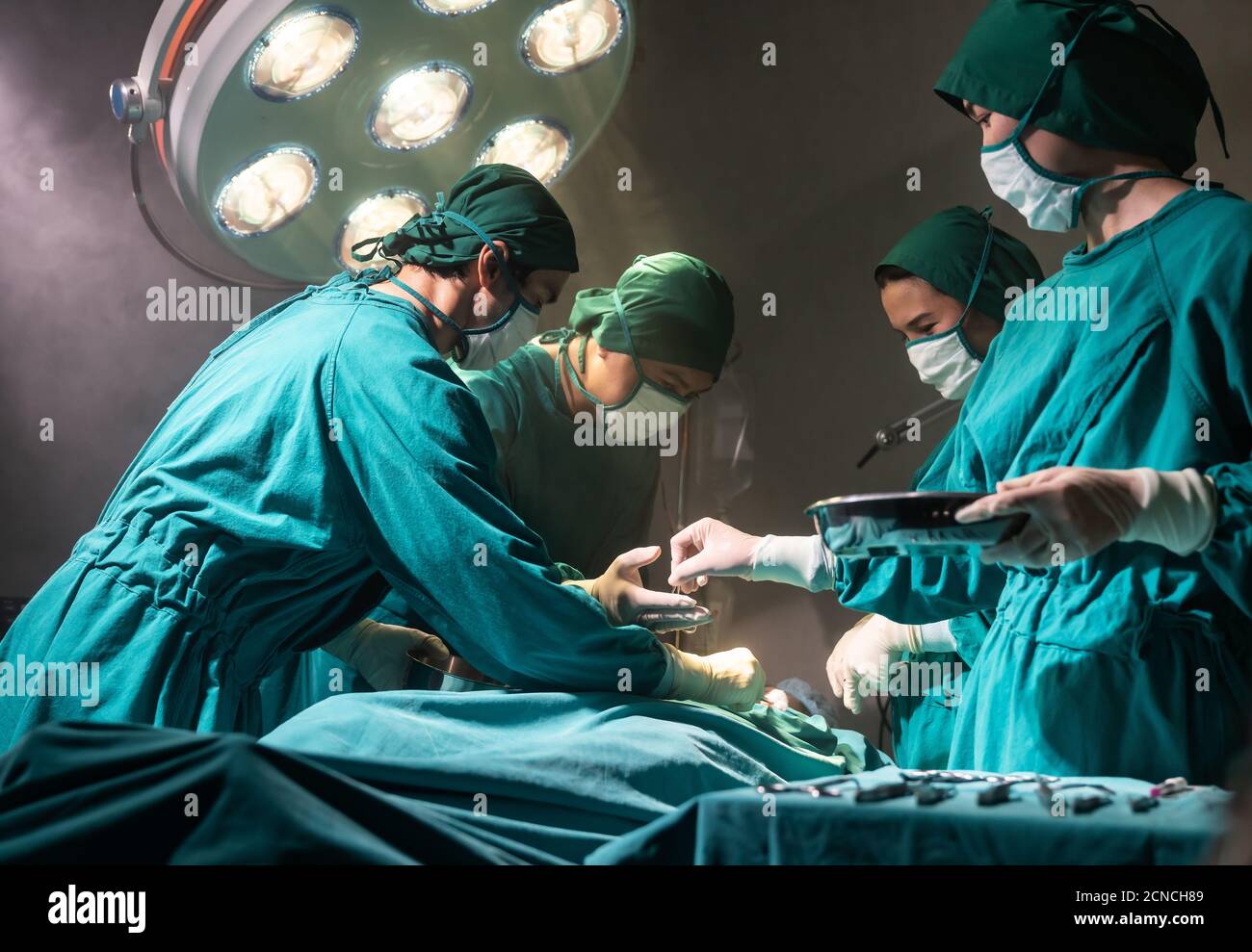 Operating room nurse send surgical equipment for surgeon doctor Stock Photo