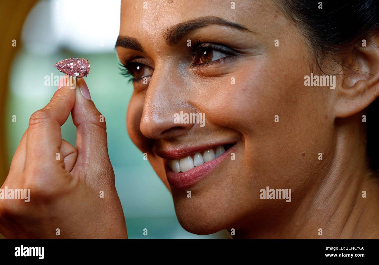 A model poses with 'The Unique Pink' diamond mounted during a preview at Sotheby's auction house in Geneva, Switzerland May 9, 2016. The supremely rare and exceptional Fancy Vivid Pink diamond, weighting 15.38 carats, is estimated to sell for US $ 28 to 38 million, when auctioned during the Magnificent Jewels and Noble Jewels auction in Geneva on May 17. REUTERS/Denis Balibouse Stock Photo