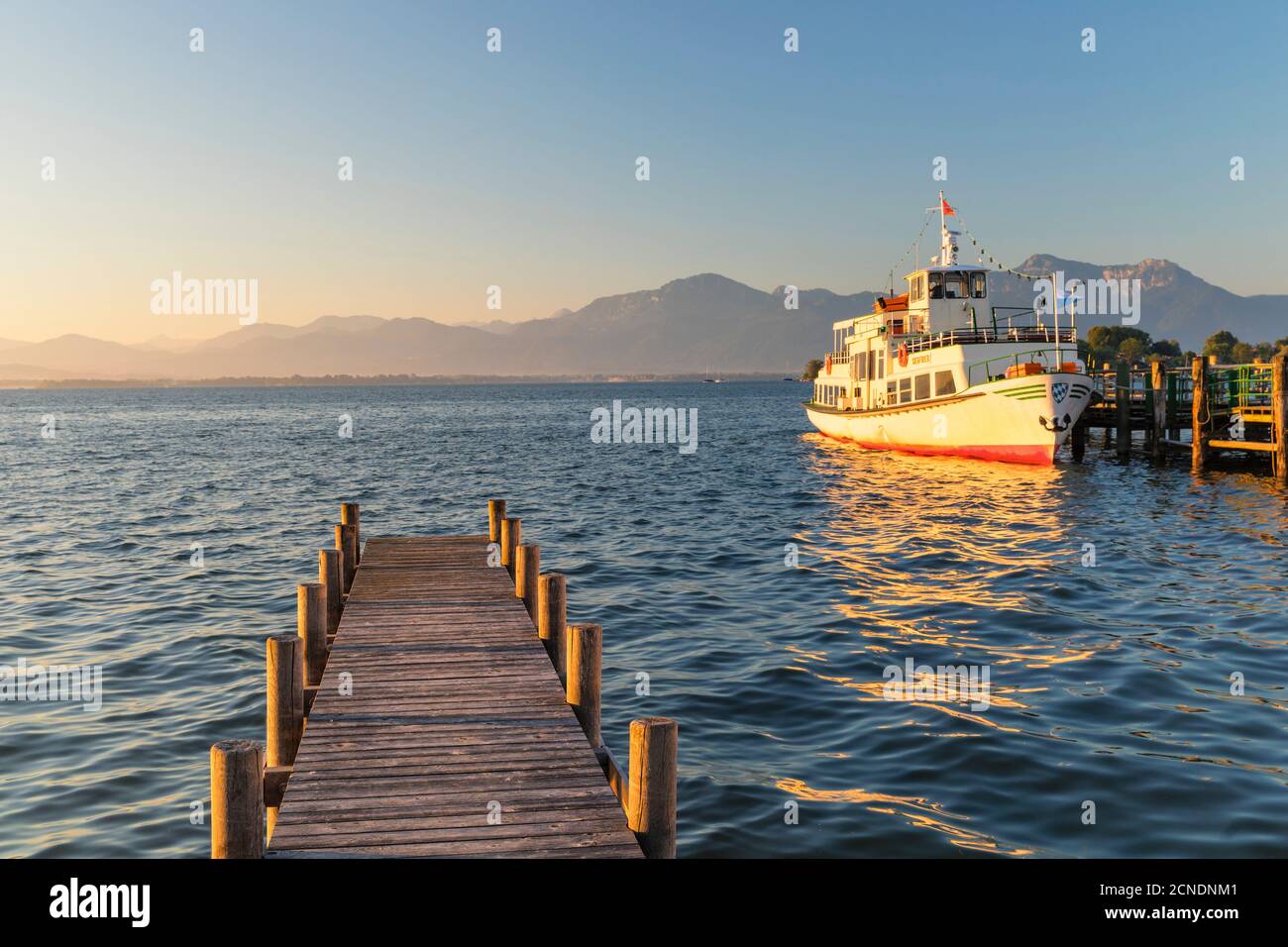 Excursion boat on a jetty at sunrise, Gstadt am Chiemsee, Lake Chiemsee, Upper Bavaria, Germany, Europe Stock Photo